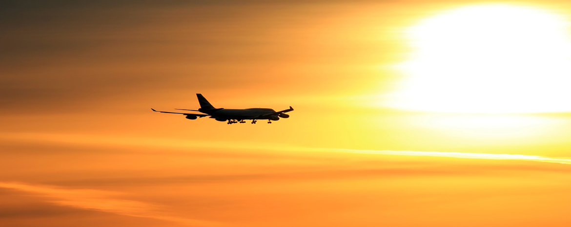 Airplane flying into the sunrise